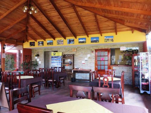 ein Esszimmer mit Tischen und Stühlen in einem Restaurant in der Unterkunft Casa del Montañero in Machachi