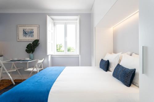 a bedroom with a large bed and a table at Duques Villa Luxury Guesthouse in Lisbon