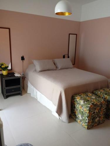 1 dormitorio con cama grande y reposapiés en Melhor ponto de Bonito en Bonito