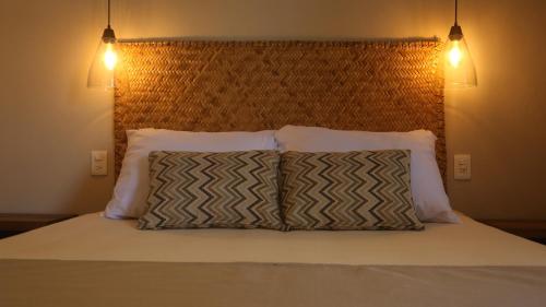 a bedroom with a bed with two pillows on it at AGAM Hotel Boutique Bacalar - Adults Only in Bacalar