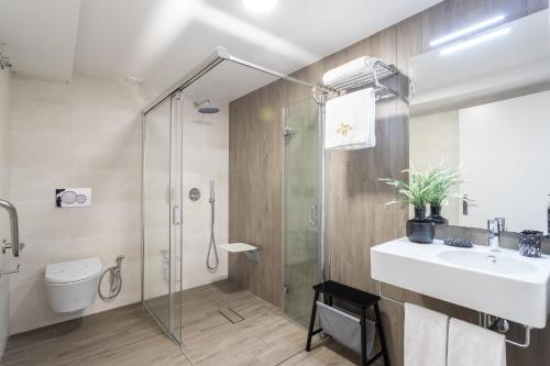 a bathroom with a shower and a sink and a toilet at Duques Villa Luxury Guesthouse in Lisbon