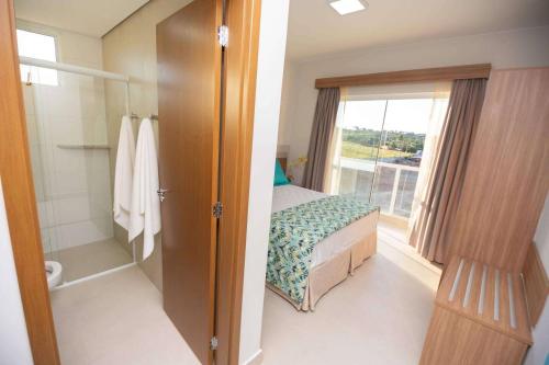 une chambre avec un lit et une salle de bain avec une fenêtre dans l'établissement Ilhas do Lago Eco Resort, à Caldas Novas