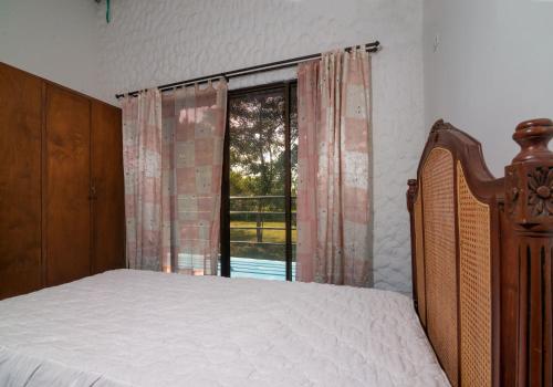 a bedroom with a bed and a large window at Casa Finca La Catalina in Montería