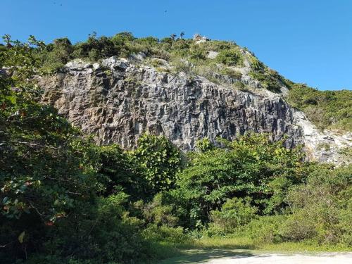 a rocky mountain with trees in front of it at Casa ampla bem localizada in Arraial do Cabo