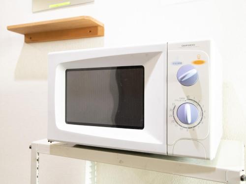 a white microwave sitting on top of a shelf at Tabist Business Hotel Kanazono Gifu in Gifu