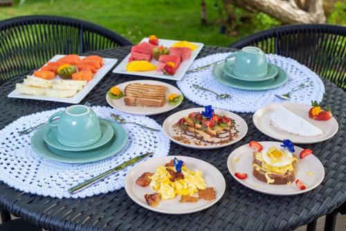 a table with plates of breakfast food on it at Wassu Pousada in São Miguel dos Milagres