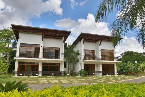 Un grand bâtiment blanc avec balcon est disponible. dans l'établissement Sybaris Suites & Residences, à Juan Dolio