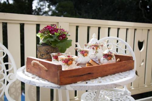 a wooden tray with cups and tea sets on a table at Tairoa Lodge in Hawera
