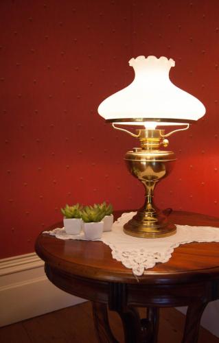 a table with a lamp on top of it at Tairoa Lodge in Hawera