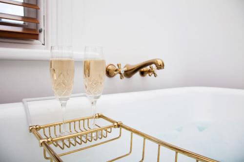 two champagne glasses on a rack next to a sink at Tairoa Lodge in Hawera