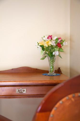 a vase of flowers sitting on top of a table at Tairoa Lodge in Hawera