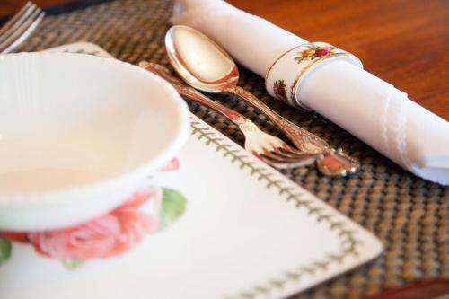 a table with forks and spoons and a plate at Tairoa Lodge in Hawera