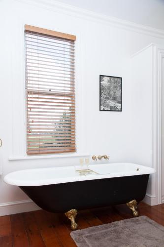 a black and white bath tub in a bathroom with a window at Tairoa Lodge in Hawera