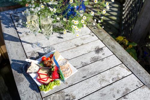 a table with a plate of food and wine glasses at Tairoa Lodge in Hawera