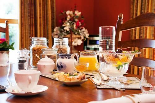 a wooden table with food and drinks on it at Tairoa Lodge in Hawera