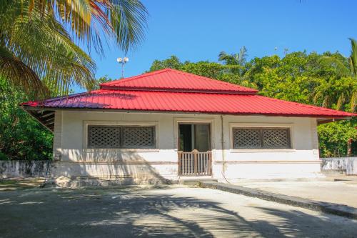 a small building with a red roof on a street at Shifa Lodge Maldives in Feridhoo
