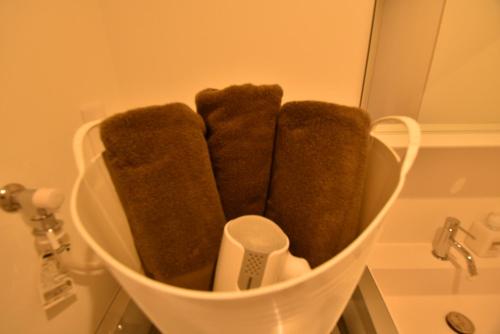 un mucchio di asciugamani marroni in un cesto in bagno di ENZO / Vacation STAY 11623 a Fukuoka