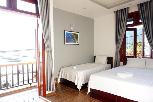 a hotel room with two beds and a balcony at Monkey Homestay & Bar in Tân Hiệp