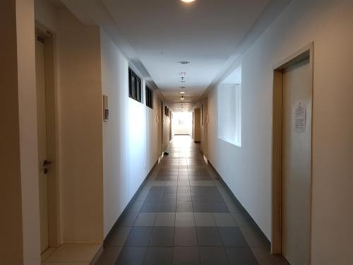 a long hallway with white walls and tile floors at Desiran @ Timurbay - seafront studio apartment with WiFi in Kuantan