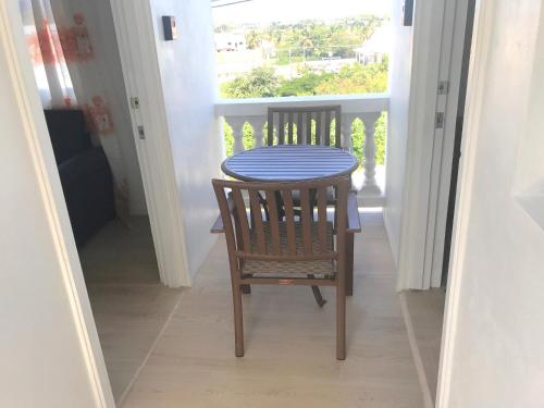 a table and a chair on a balcony at Cleopatra Villas - Sea View in Rodney Bay Village