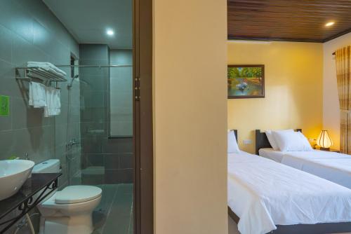 a bathroom with a bed and a toilet and a shower at Old Lane Homestay in Hoi An