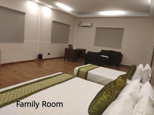 a room with two beds and a family room at Serene Valley Hotel in Yangon