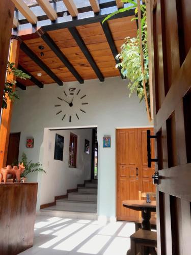a clock on the wall of a building with stairs at Hotel Casa Azabache in San Cristóbal de Las Casas