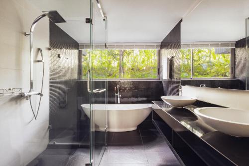 a bathroom with two sinks and a bath tub at The Pavilions Phuket in Bang Tao Beach