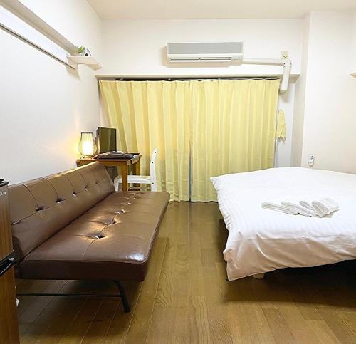 a room with a couch and a bed and a desk at La Foret Fujimi in Hiroshima