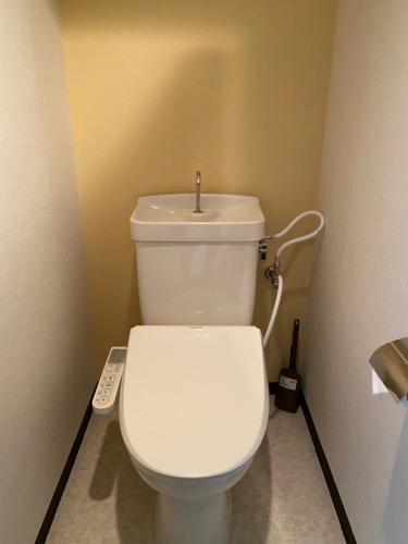 a bathroom with a white toilet with a sink at La Foret Fujimi in Hiroshima