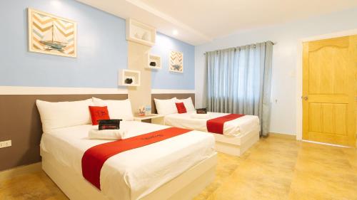 Cette chambre comprend 2 lits et une fenêtre. dans l'établissement RedDoorz near Lapasan Plaza Cagayan de Oro, à Cagayán de Oro