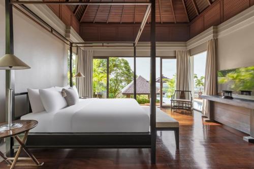 a bedroom with a bed and a large window at The Pavilions Phuket in Bang Tao Beach