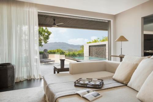 a living room filled with furniture and a window at The Pavilions, Phuket - SHA Extra Plus in Bang Tao Beach