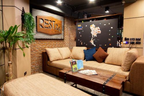a living room with two couches and a table at Rest24 Residence in Bangkok
