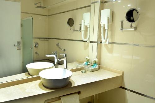 a bathroom with two sinks and a mirror at Hotel Capvio in Villa Carlos Paz