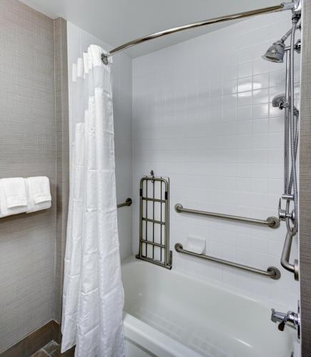 a bathroom with a shower with a white shower curtain at Holiday Inn Savannah Historic District by IHG in Savannah