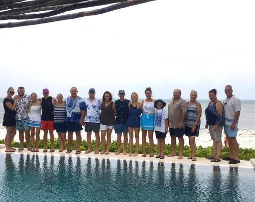 a group of people standing next to the water at Driftwood Beach Lodge in Jambiani