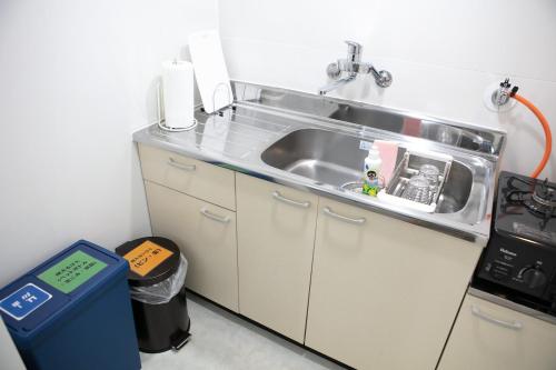a kitchen with a sink and a trash can at Villa BluMare Shirahama in Shirahama