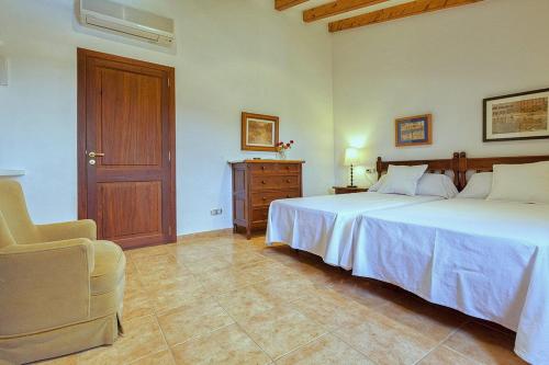 a bedroom with two beds and a chair in it at Finca Antonio in Búger