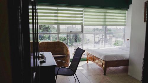 1 dormitorio con cama, mesa y ventana en 2428 Suites en Urdaneta