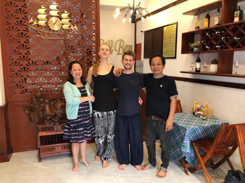 a group of people posing for a picture in a room at Bill Ben Homestay Hoi An in Hoi An