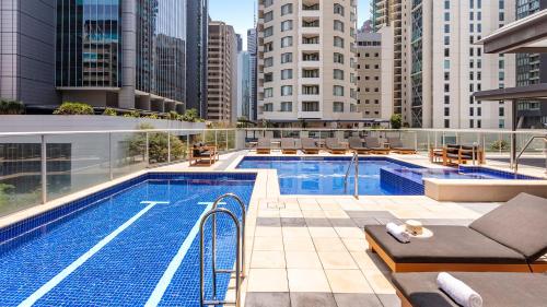 a swimming pool on top of a building with tall buildings at Oaks Brisbane Festival Suites in Brisbane