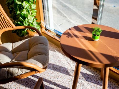 a wooden table and chair with a potted plant on it at The Moana by DSH Resorts in Chatan