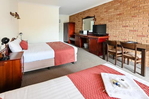 A bed or beds in a room at Narrandera Club Motor Inn