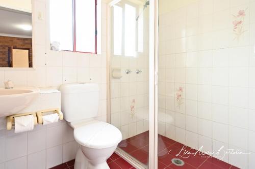 a white toilet sitting next to a bathroom sink at Narrandera Club Motor Inn in Narrandera