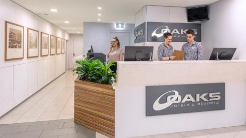 three people standing at a counter in a dental office at Oaks Brisbane Festival Suites in Brisbane