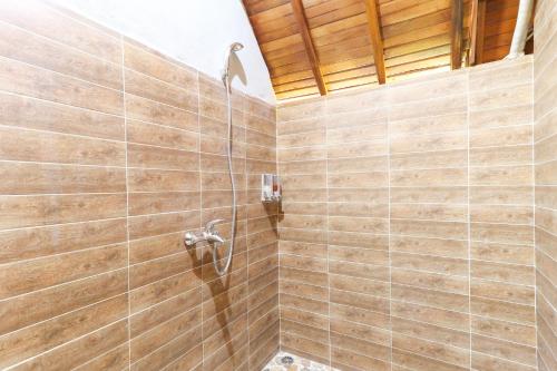 y baño con ducha y paredes de madera. en Bougainvillea Bungalow, en Nusa Penida