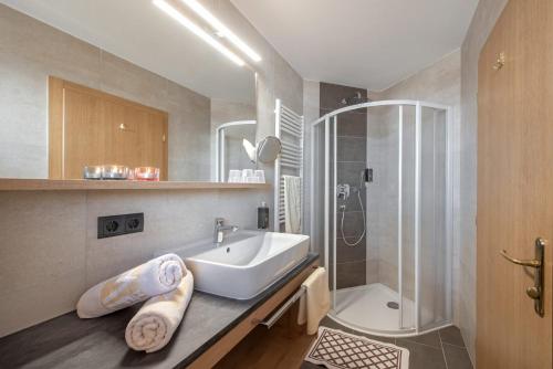 La salle de bains est pourvue d'un lavabo et d'une douche. dans l'établissement Holiday Residence Mesenhaus, à Maranza