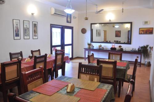 a dining room with tables and chairs and a mirror at Niketana @ Boat Club in Chennai