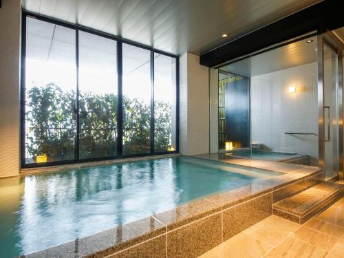 a swimming pool in a house with a large window at Hotel Honnoji in Kyoto